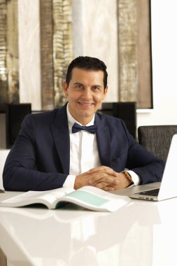 Evde bilgisayarıyla çalışan şık genç bir yönetici. İçişleri Bakanlığı