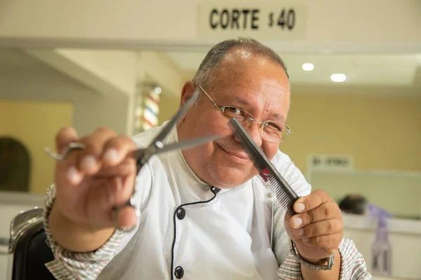 Olgun bir kuaför, kuaföründe mutlu ve gülümsüyor.