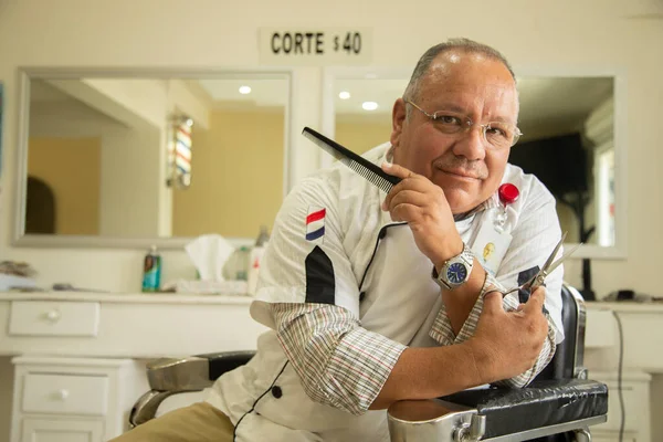 Olgun bir kuaför, kuaföründe mutlu ve gülümsüyor.