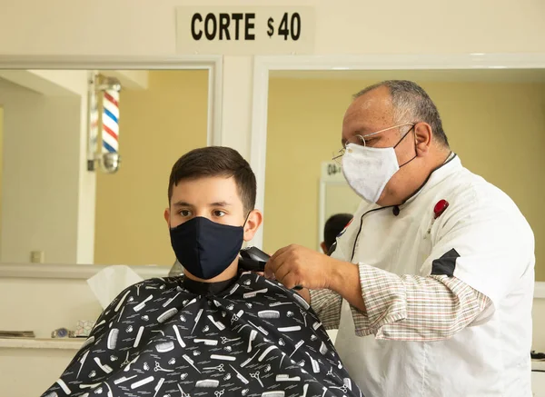 Happy Latino Holič Stříhání Vlasy Dospívající Chlapec Nošení Ochranné Masky Stock Obrázky