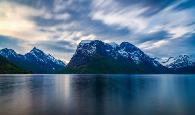 Mavi göl suyu ve dağlar, akşam 