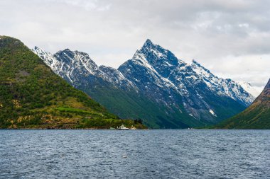 Göl suyunda yüzen tekne, dağlar. 