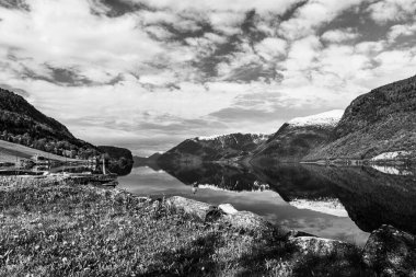 Siyah beyaz fotoğraf, dağlardaki görkemli göl suyu. 