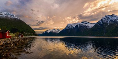 Dağlardaki göldeki kırmızı ahşap kulübe.