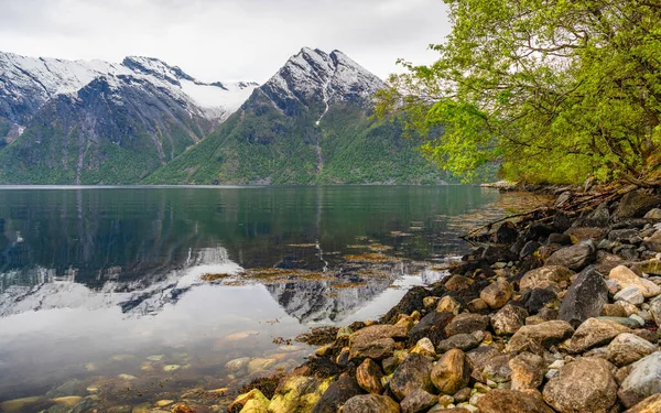 rocks at lake water, mountains on background