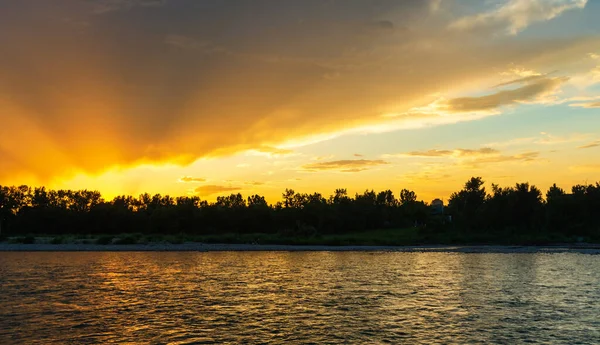 Sakin bir nehir ve yemyeşil bitki örtüsüyle güzel doğal bir manzara.