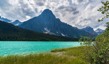 Banff Ulusal Parkı, Alberta, Kanada 'daki zümrüt gölü ve manzaralı dağlarla güzel bir manzara.