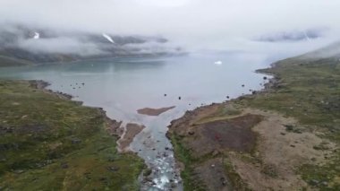 Danimarka 'nın Faroe Adaları, Arnafjordur köyünü çevreleyen Misty Fjord ve Dağları üzerindeki İHA uçuşu
