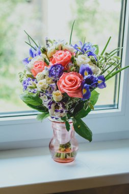 Beyaz bir pencerede vazoda soluk pembe güller.