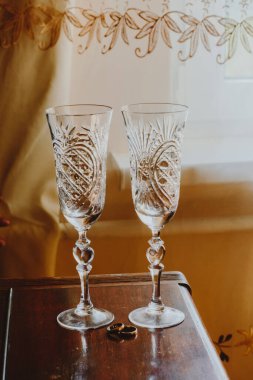 İki kutsal kristal bardak, evlilik yüzüğünün yanında.