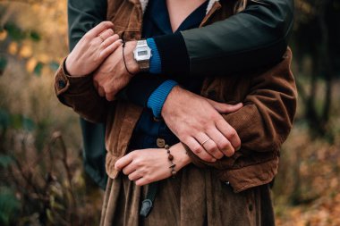 Sarılmış bir kızla bir erkeğin elleri.