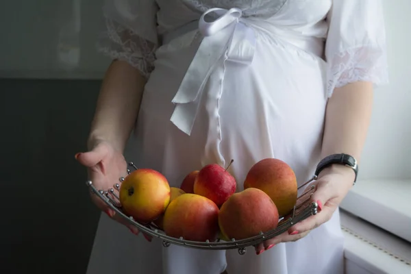 Olgun Elmalarla Dolu Beyaz Elbiseli Hamile Bir Kadın — Stok fotoğraf