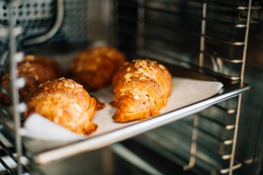 Kağıt üzerinde fırında kruvasan pişiyor.