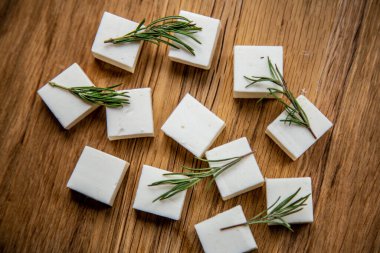 Süzme peynir dilimleri doğranır ve yeşilliklerle süslenir.