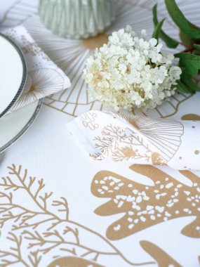 Masa ayarı. Çiçekler, tabaklar, parmak izli parlak masa örtüsü.