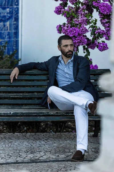 Handsome Portuguese guy wearing a stylish medieval jacket clothes while walking in the streets of Lisbon in Portugal. Beautiful middle age man relaxing with an elegant jacket in the city center