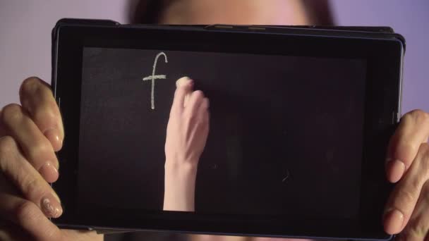 Zblízka žena drží tablet PC s on-line výuky. Ručně píše na tabuli slova otec a matka — Stock video