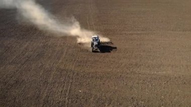 Mavi traktörün hava görüntüsü tarlada çiftçi sürüşü