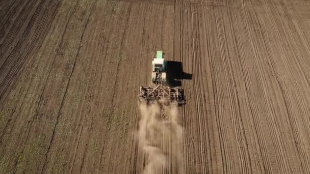 Großer leistungsstarker Traktor pflügt Feld in Staub und bereitet Land für die Aussaat vor