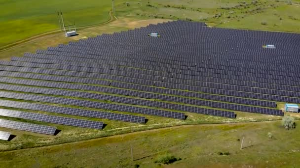 Images aériennes de centaines de modules solaires ou de panneaux pour générer des rangées d'électricité écologique le long des champs agricoles verts 