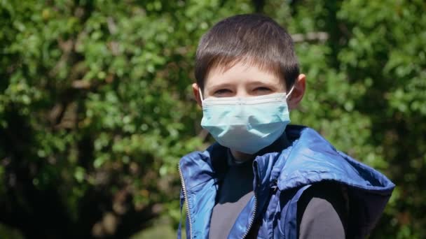 Quarantaine et menace de coronavirus. Triste garçon enfant en masque médical pour la prévention du SRAS — Video