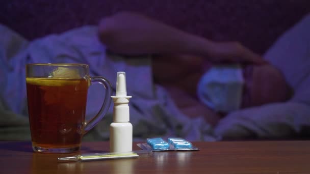 Té caliente con limón y tabletas contra el fondo del hombre enfermo en máscara médica protectora — Vídeos de Stock