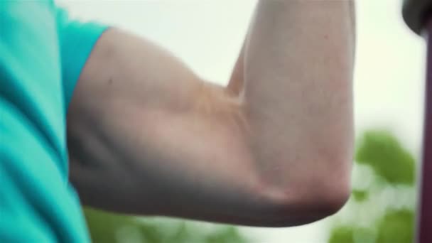 Feche o jovem atleta esportista do sexo masculino treinando e fazendo pull ups na barra horizontal. outdooors treino no verão — Vídeo de Stock