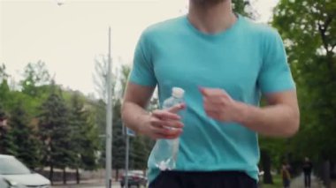 Yaz parkında koşucu eğitimi. Spor salonunu kapatan erkek dışarıda koşuyor.