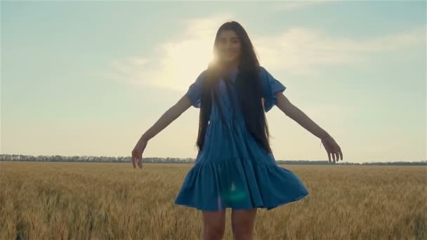Slow motion of young beautiful woman in blue dress breathe deeply in field to enjoy purity of nature — Stock Video