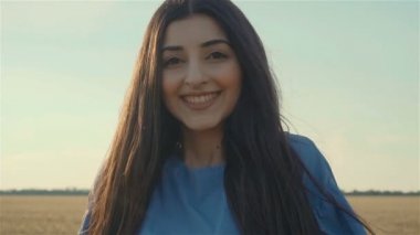 Güzel bir kadının yakın portresi. Huzurlu günbatımının tadını çıkarıyor ve rüzgar saçlarını savurarak ruhaniliği keşfediyor.