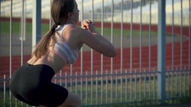 Zayıf vücutlu genç atletik bir kadının kardiyo egzersizi yapması ve spor giysileri içinde atlaması.