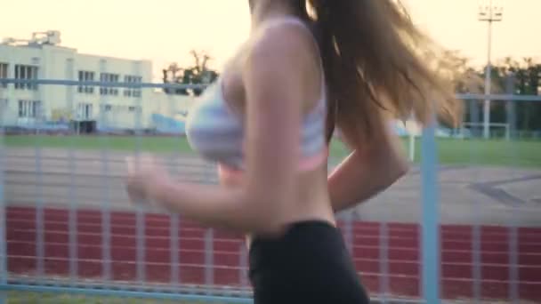 Junge kaukasische Frauen trainieren mit Outdoor-Lauftraining mit Stadionhintergrund und Sonnenuntergängen im Sommer — Stockvideo