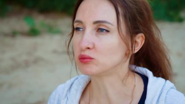 Odaklanmış ifade ve sakin tavır ile erik yiyen bir kadın. Dişi eriği ısırıyor ve düşünceli bir anda usulca bakıyor. Huzurlu ve sakin meyveyi seven bayan.