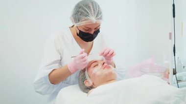 Kadın gelişmiş kozmetik aletleri kullanarak cilt kusurlarını tedavi ediyor. Sivilceleri dikkatlice inceleyen ve deri dokusunu geliştiren bir kadın. Pürüzsüz ten rengini güvence altına almak için profesyonel gençleştirme prosedürüne tabi tutulan kız