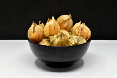 Siyah ve beyaz arka planda siyah kasede yenilebilir bitki özü.