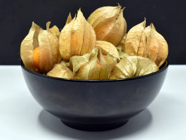 Siyah ve beyaz arka planda siyah kasede yenilebilir bitki özü.