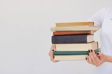  Güzel genç bir öğrenci kitapları elinde tutuyor.