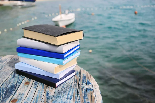 Sahilde, deniz kenarında yığınla kitap.