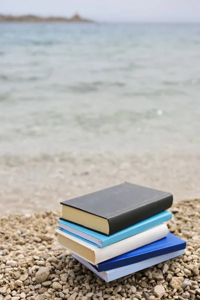 Stack of books on the beach by the sea