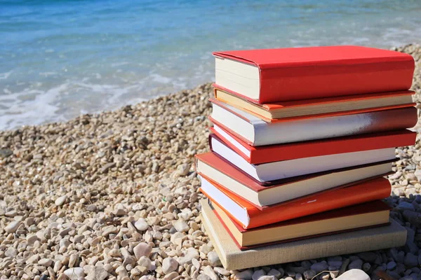 Stack of books on the beach by the sea