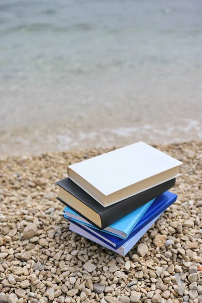 Stack of books on the beach by the sea