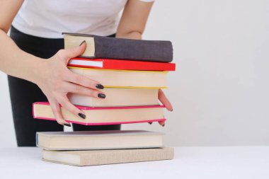 Güzel genç bir öğrenci kitapları elinde tutuyor.