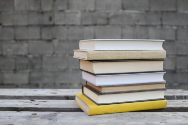 Duvarın önündeki ahşap bankta kitaplar