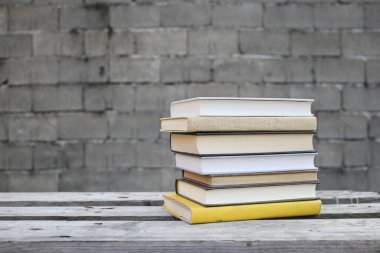 Duvarın önündeki ahşap bankta kitaplar