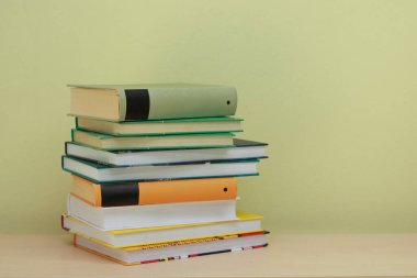 Sarı arkaplan üzerine kitap yığını