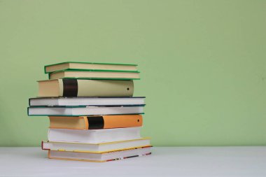 Yeşil arkaplan üzerine kitap yığını
