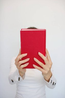  Genç bir kız elinde bir kitap tutuyor.