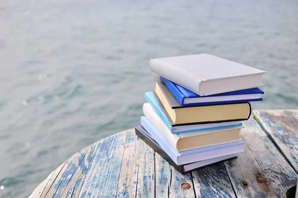 Sahilde, deniz kenarında yığınla kitap.