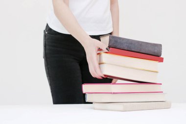  Güzel genç bir öğrenci kitapları elinde tutuyor.