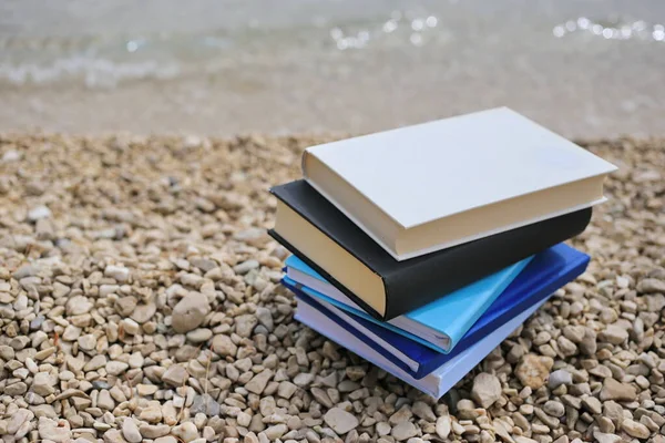 Stack of books on the beach by the sea